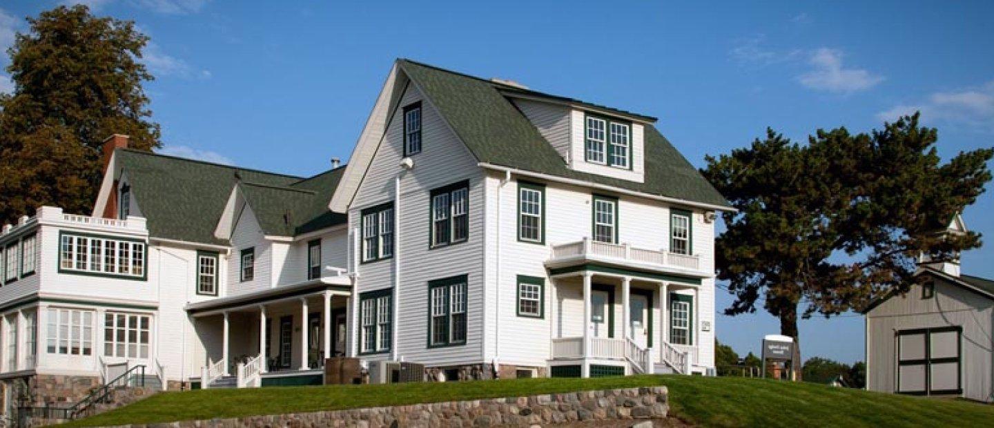 large white house with a green roof and trim