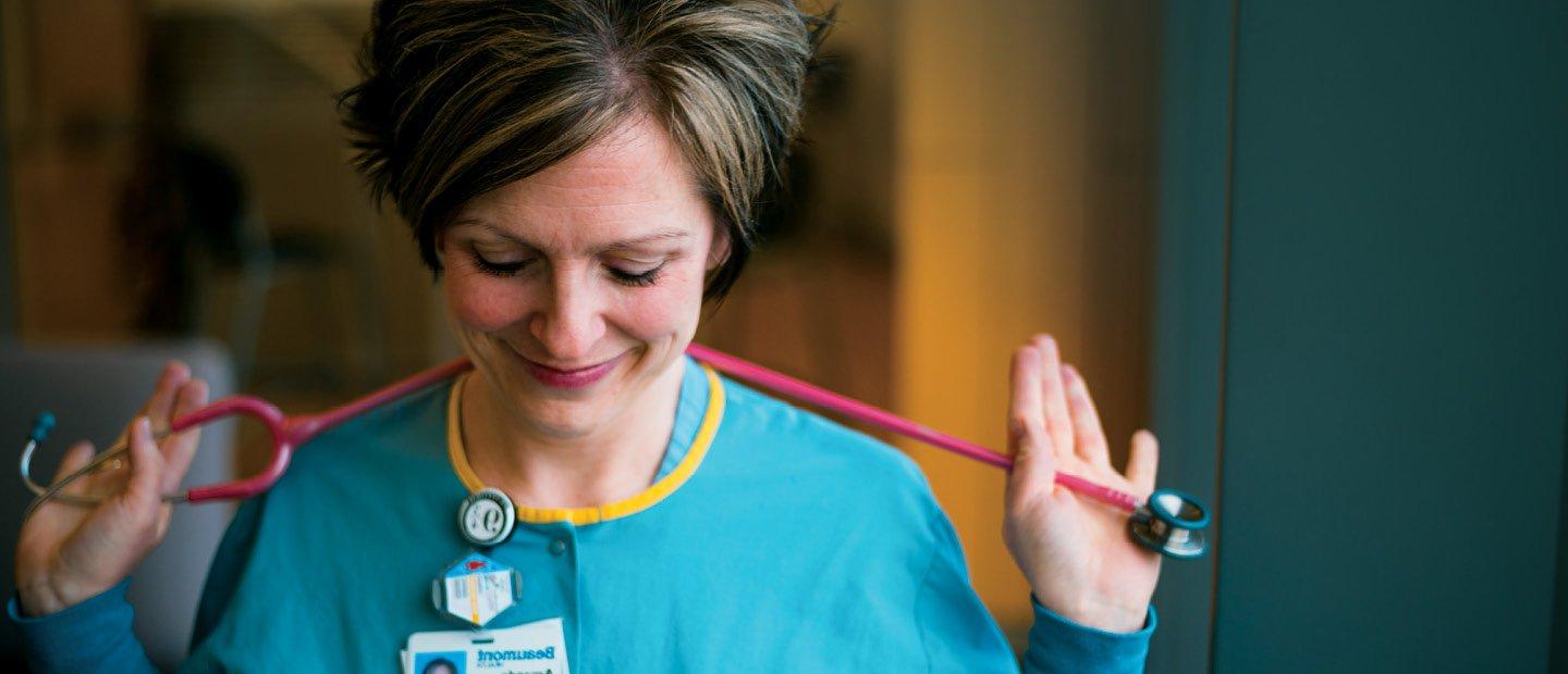 woman in a blue lab coat with a stethoscope around her neck