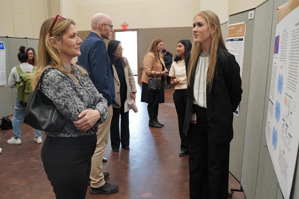 An image of an OUWB student presenting her poster