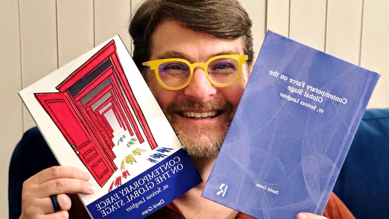 David Gram with his book, "全球舞台上的当代闹剧:或者, 严重的笑声"